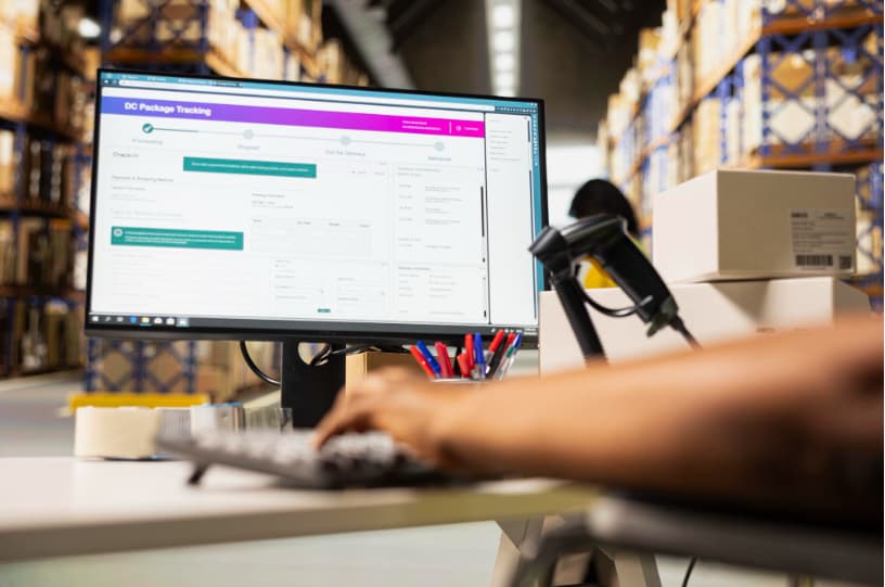 Operador logístico gestionando seguimiento de envíos en sistema digital desde bodega